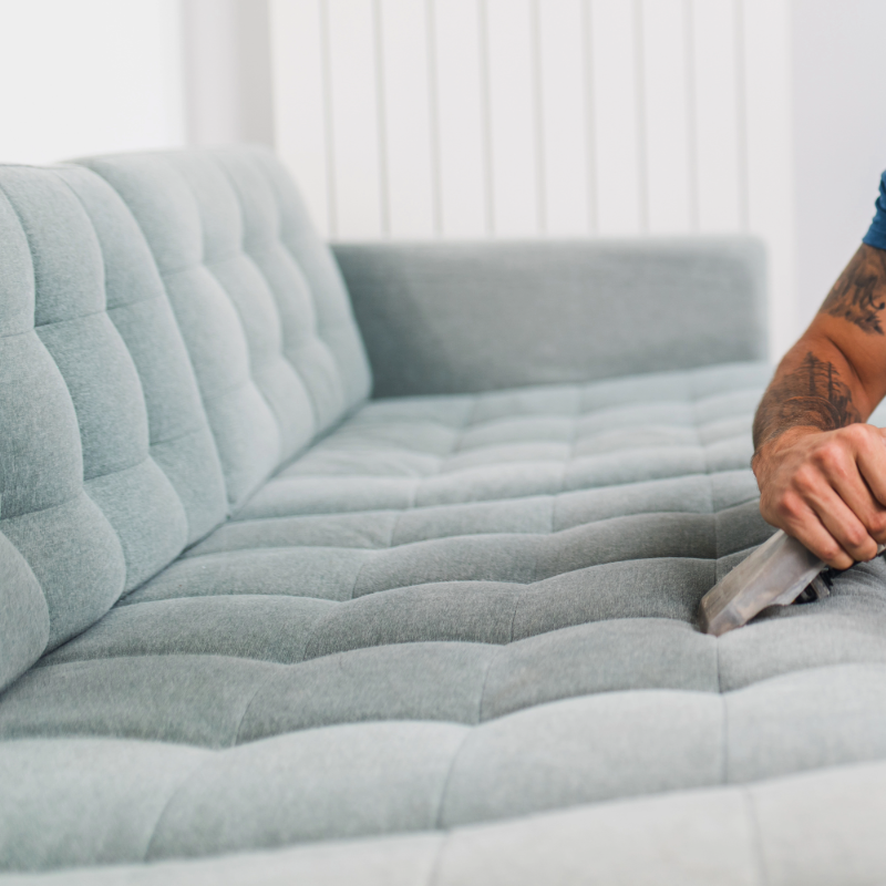Professional upholstery cleaning in progress on a sofa